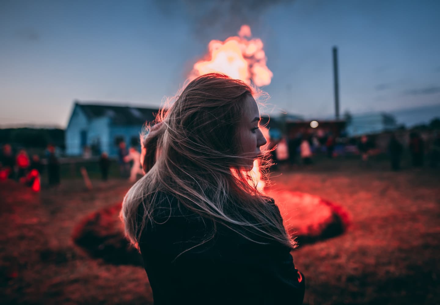 a women looking at a bonfire at night