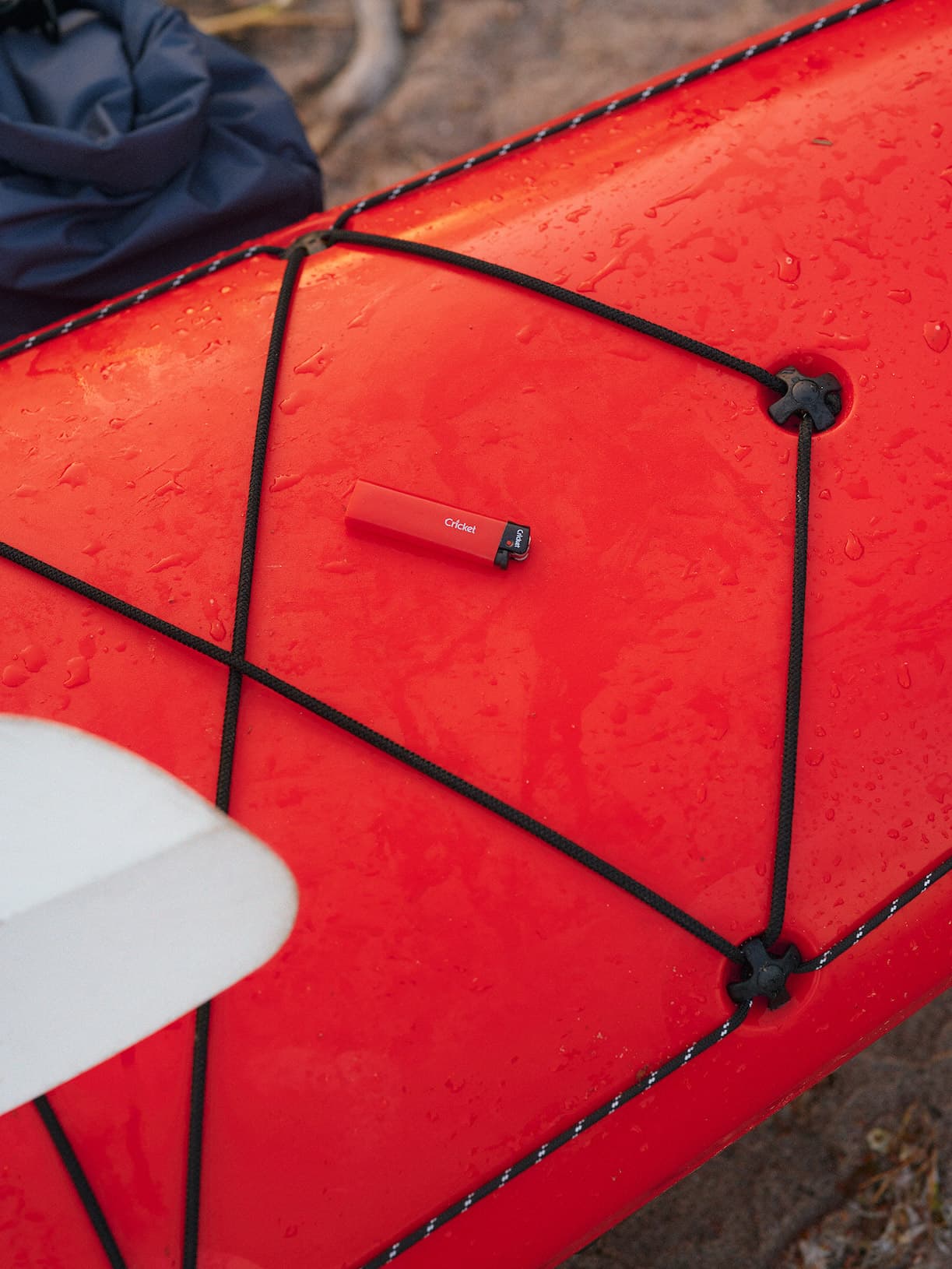 Closeup of a red kayak with a red Cricket lighter on it