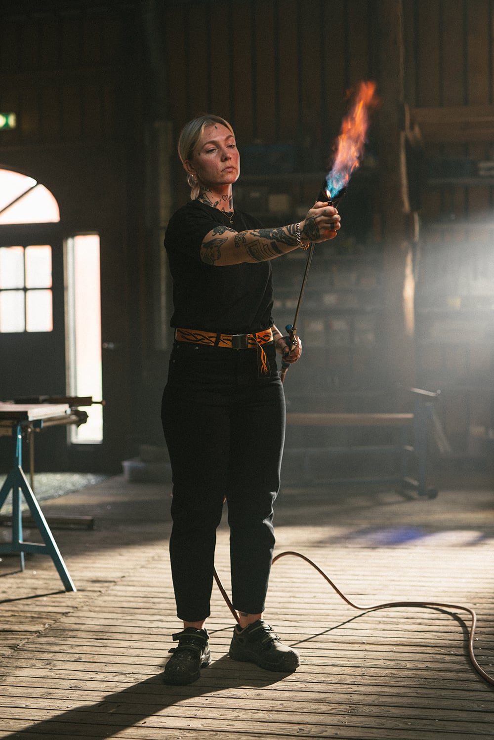 A blond woman lighting a fire