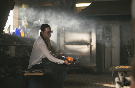 A woman in a glassblowing studio